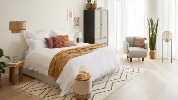 Cama acogedora con mantas y cojines, ideal para un ambiente de feng shui.