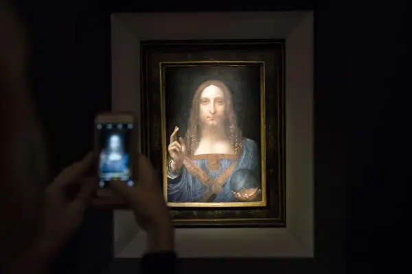 Persona toma foto a Salvator Mundi, el cuadro más caro del mundo, con su móvil.